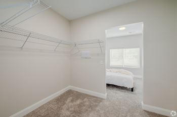 A bedroom with a bed, a window with blinds, and a closet with hanging rods. at Park Lamont Townhomes Apartments, Cleveland, OH
